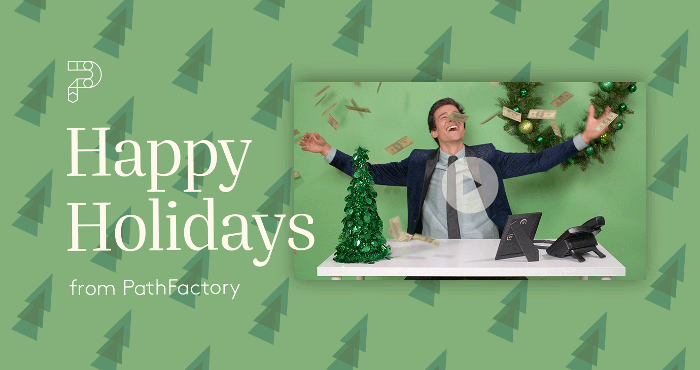 Header Image with a Green Background with cartoon patterned Christmas Trees, on the left of the image is PathFactory's logo with the title "Happy Holidays from PathFactory" and to the right of the text is the thumbnail for the video with a man in a suit at a desk with Christmas decorations on it singing joyfully with his arms outstretched.